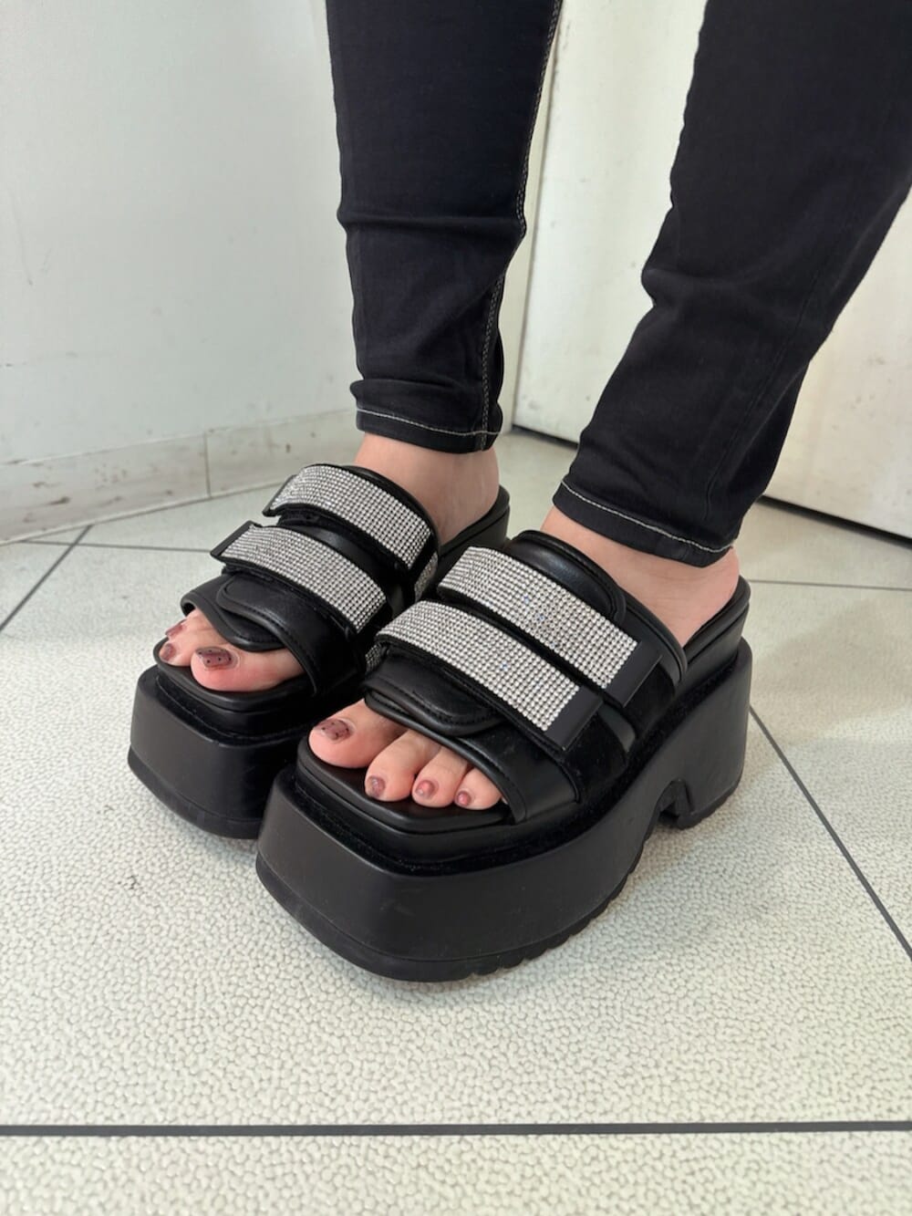 ブラック系のデニムパンツ、ブラック系のサンダル、ホワイト系のカーディガン/ボレロを着用したレディースの春コーディネートの9枚目の写真