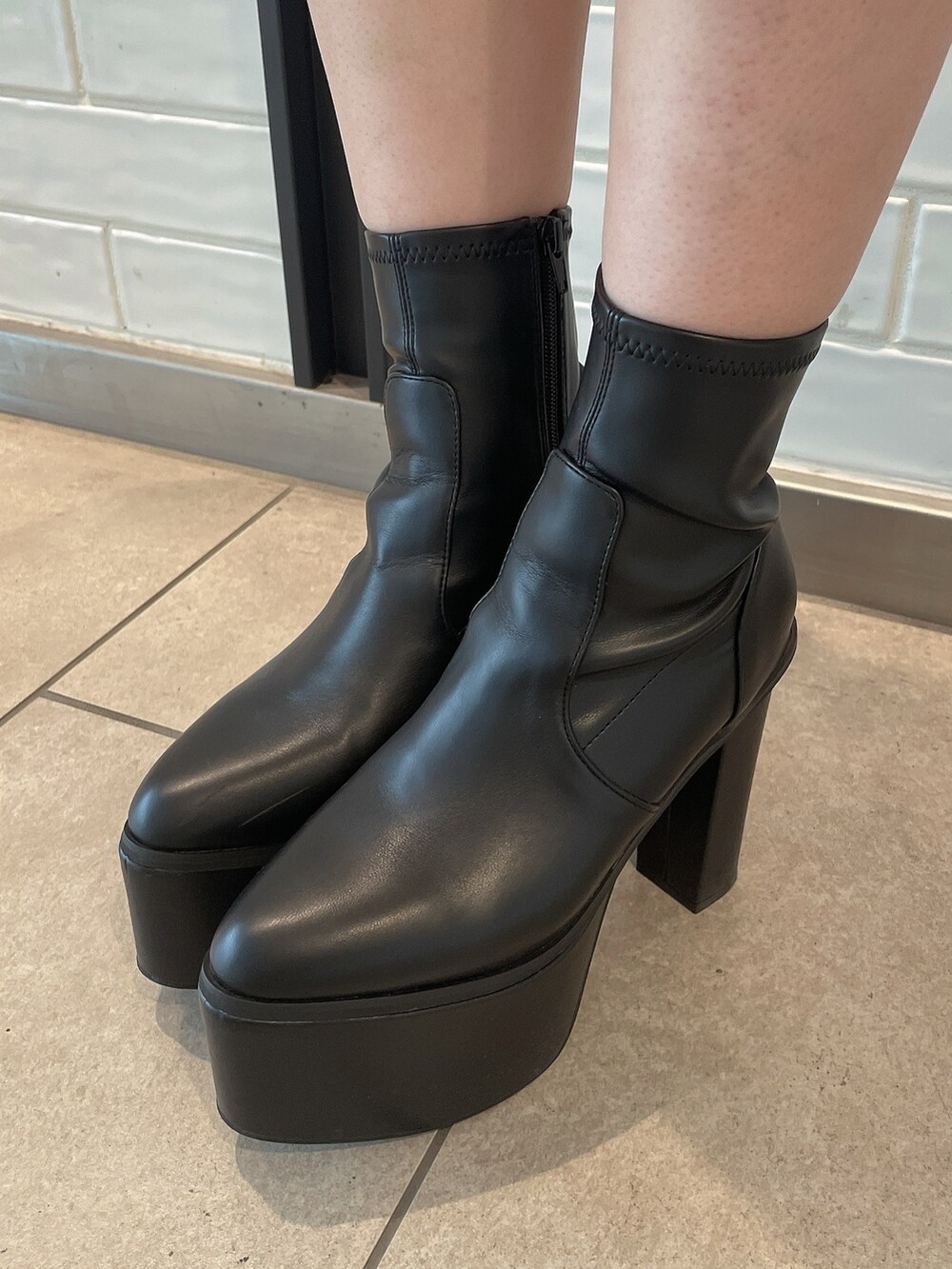 ブラック系のデニムパンツ、ブラック系のブーツ、その他のニット/セーターを着用したレディースの秋コーディネートの10枚目の写真