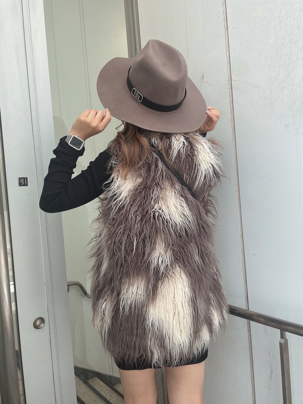 ブラック系のワンピース、その他のベスト、ブラック系のハンドバッグを着用したレディースの秋コーディネートの5枚目の写真