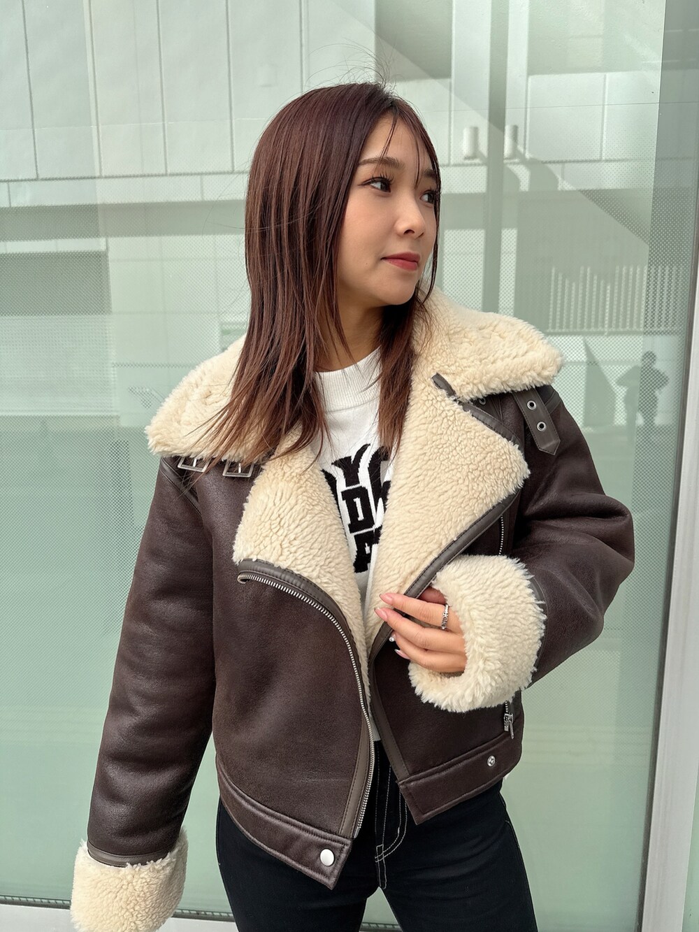 ブラック系のデニムパンツ、ブラック系のブーツ、ホワイト系のニット/セーターを着用したレディースの秋コーディネートの4枚目の写真