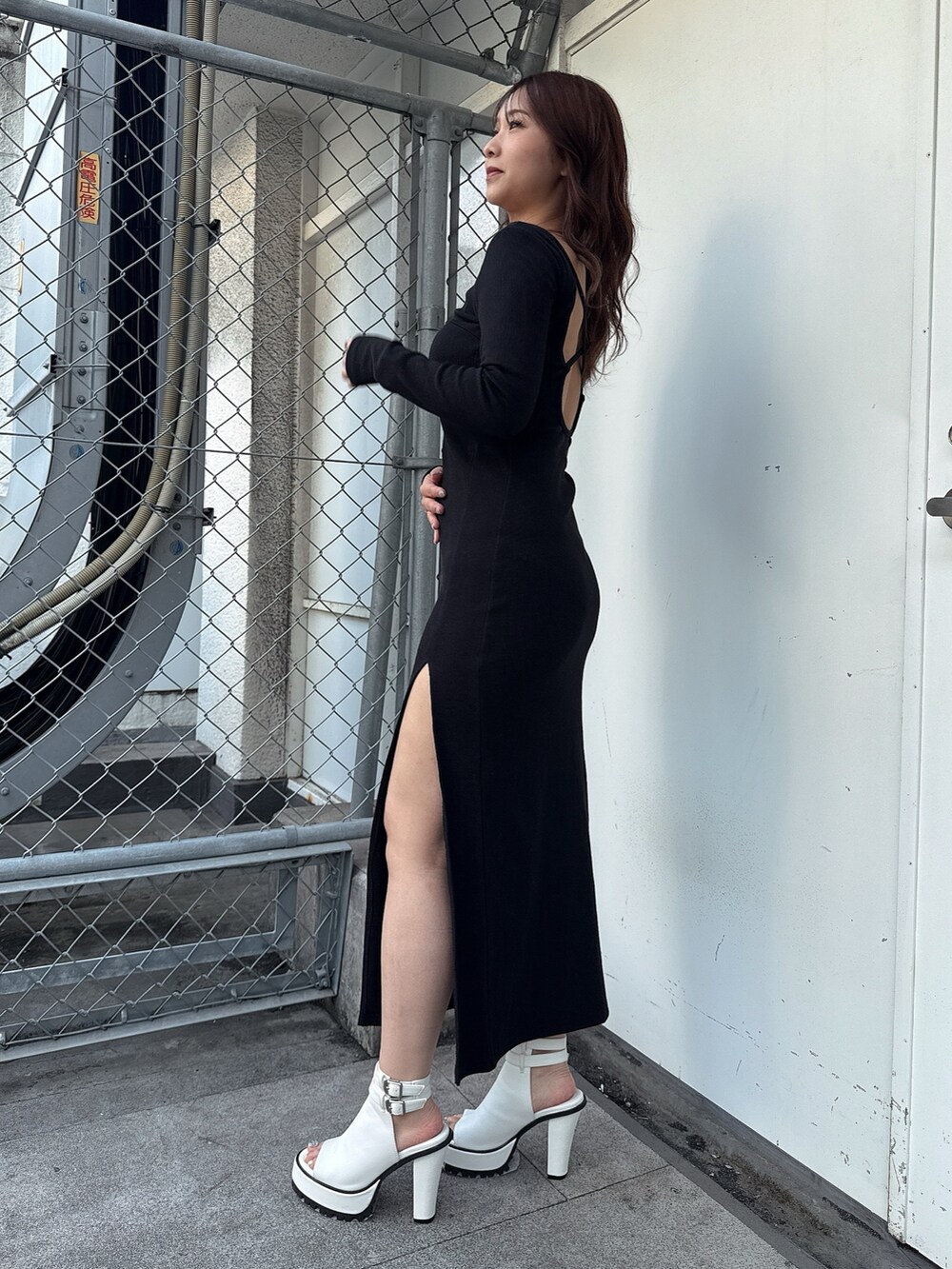 ブラック系のワンピース、ホワイト系のブーツを着用したレディースの春コーディネートの2枚目の写真