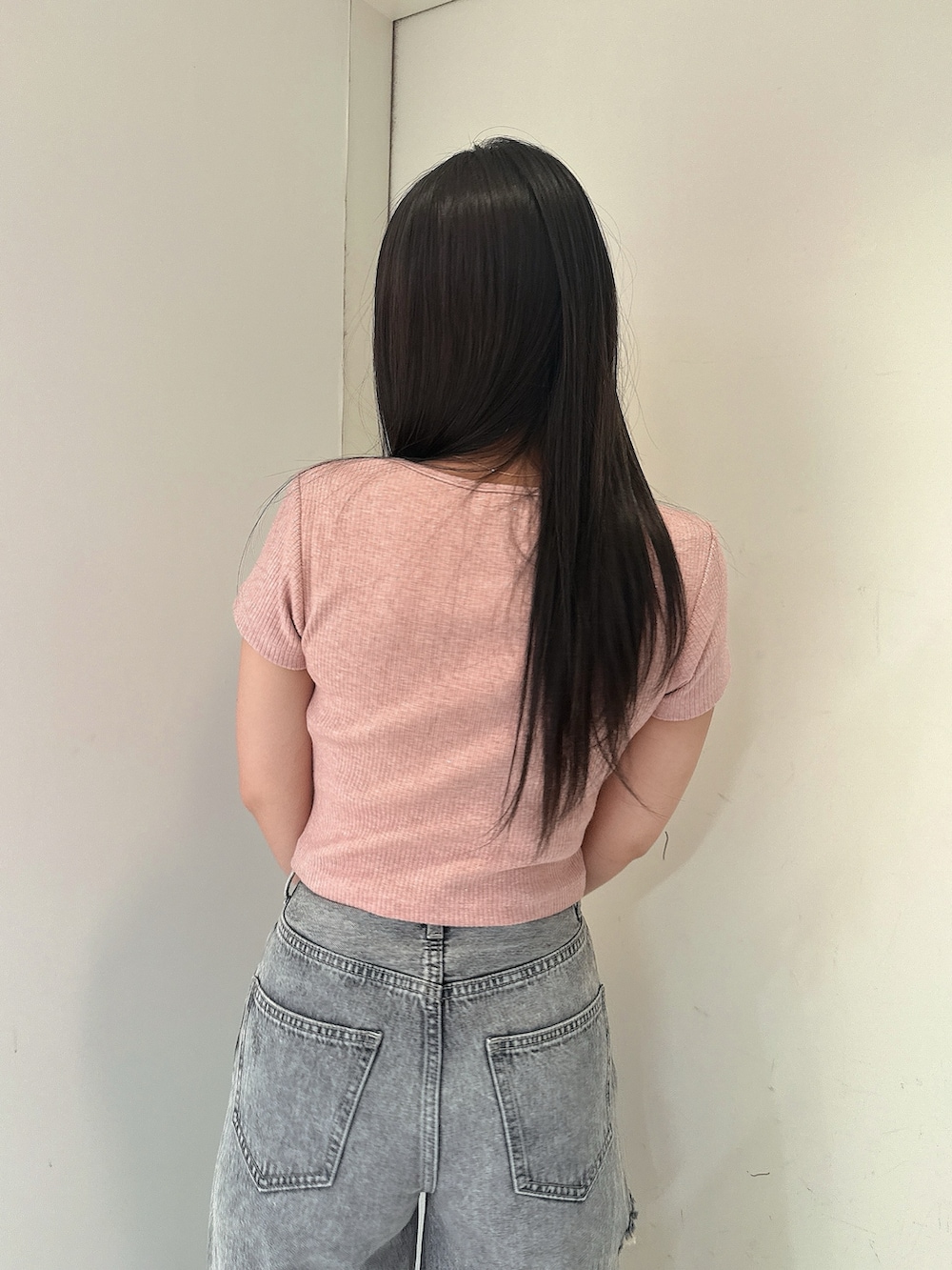 ブルー系のデニムパンツ、ピンク系のTシャツ/カットソー、ブラック系のサンダルを着用したレディースの春コーディネートの6枚目の写真
