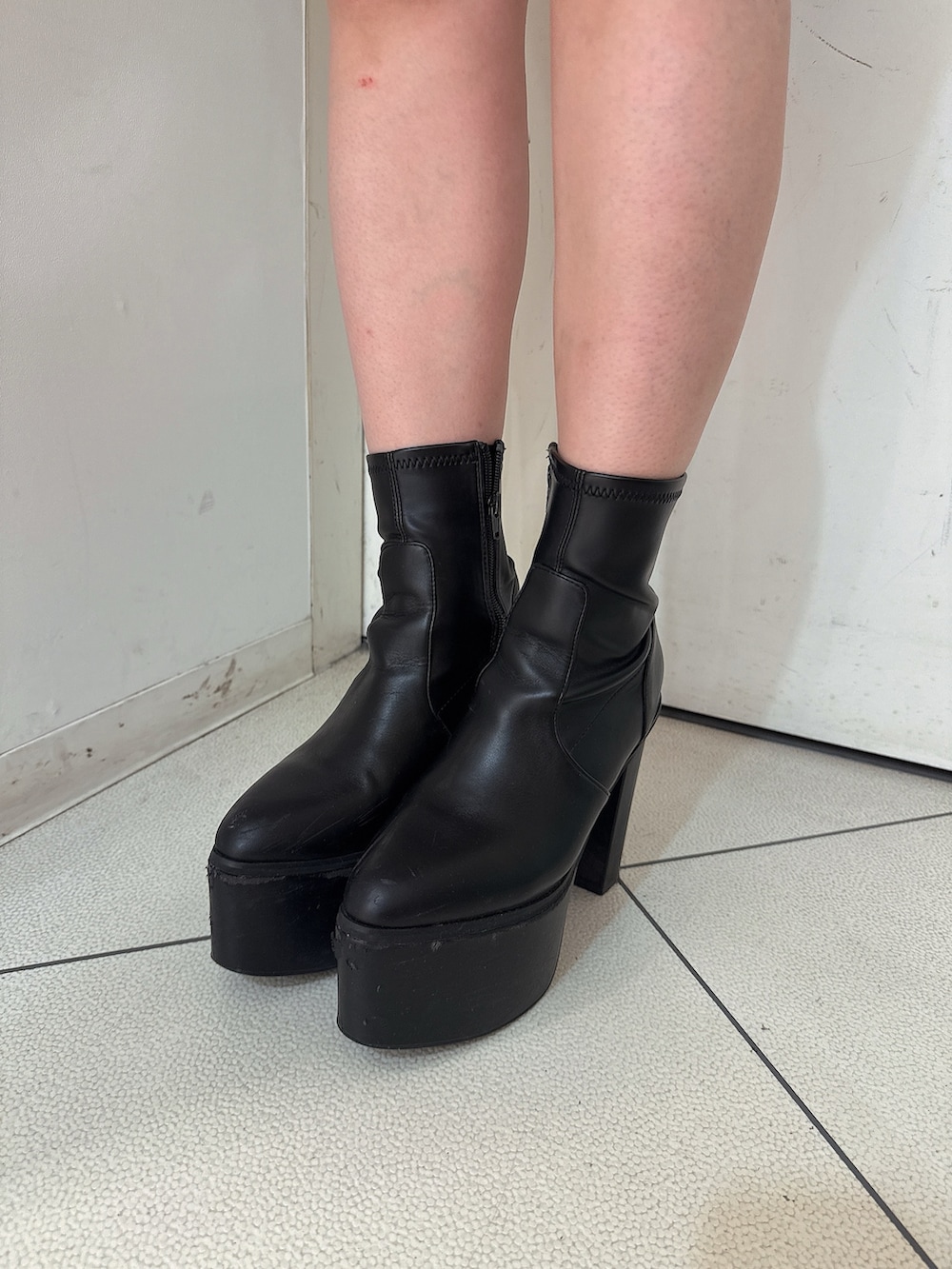 ブルー系のデニムスカート、ブラック系のブーツ、ホワイト系のニット/セーターを着用したレディースの冬コーディネートの9枚目の写真