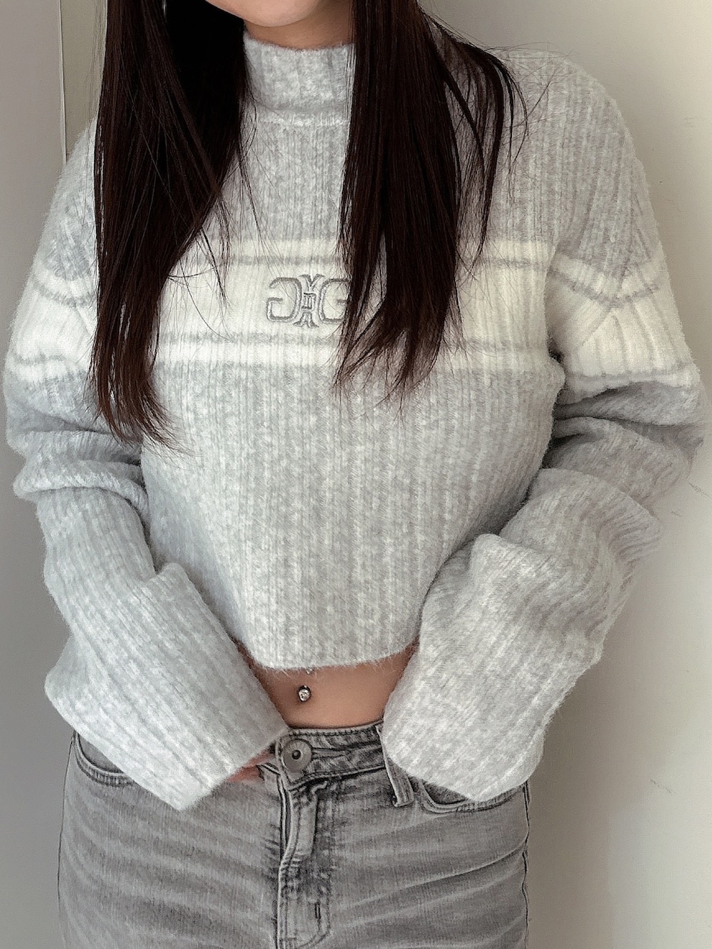 グレー系のデニムパンツ、ブラック系のブーツ、グレー系のニット/セーターを着用したレディースの冬コーディネートの4枚目の写真