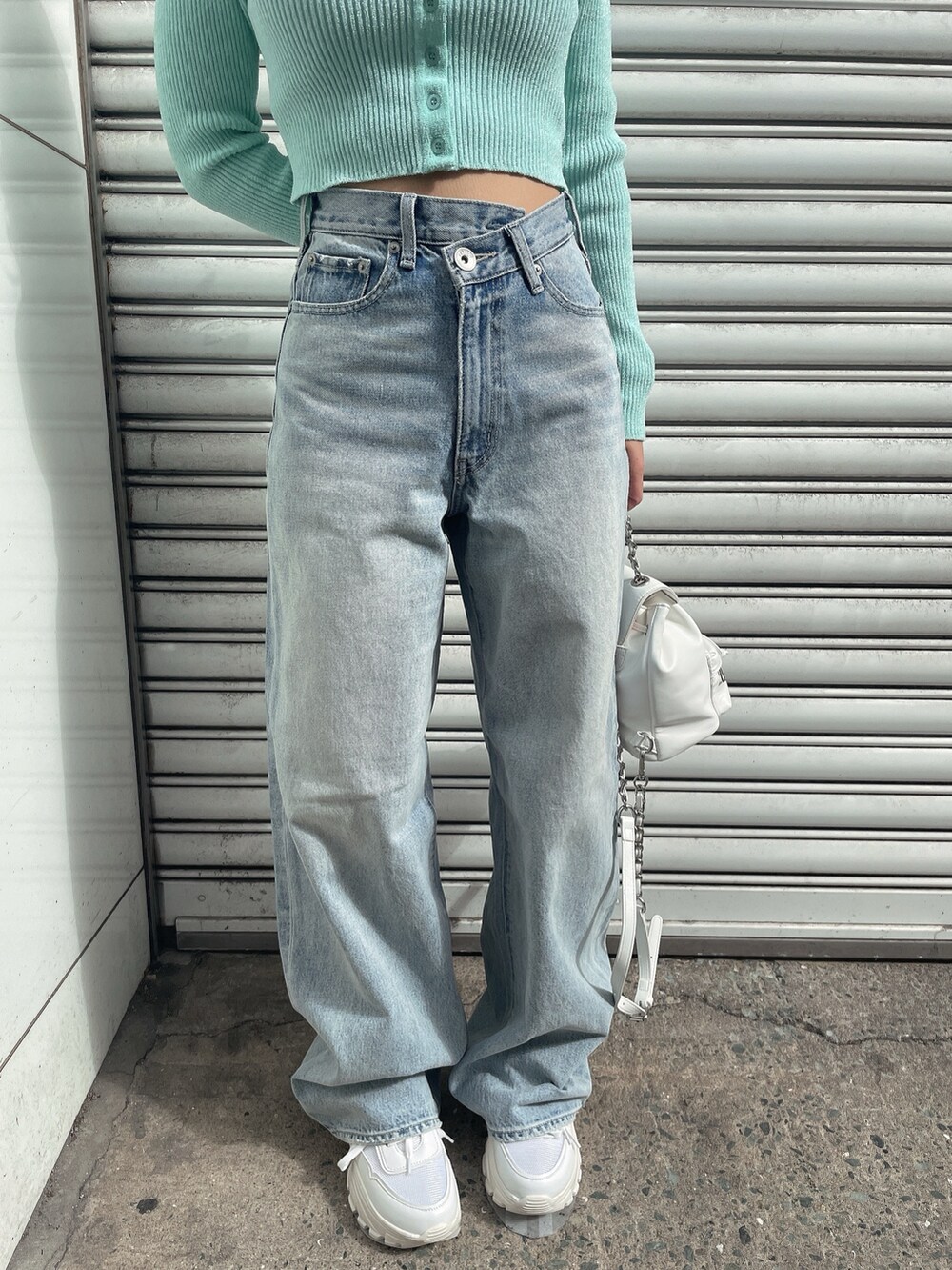 グリーン系のカーディガン/ボレロ、ブルー系のデニムパンツ、ホワイト系のバックパック/リュックを着用したレディースの冬コーディネートの9枚目の写真