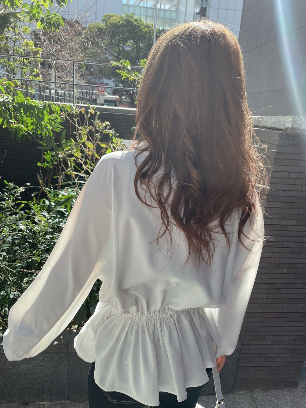 ブラック系のキャミソール、ホワイト系のシャツ/ブラウス、ホワイト系のハンドバッグを着用したレディースの冬コーディネートの5枚目の写真