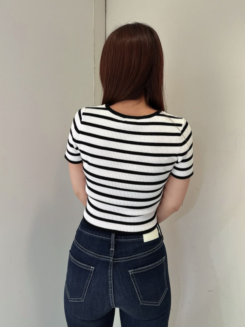 ブルー系のデニムパンツ、ブラック系のサンダル、その他のニット/セーターを着用したレディースの春コーディネートの6枚目の写真