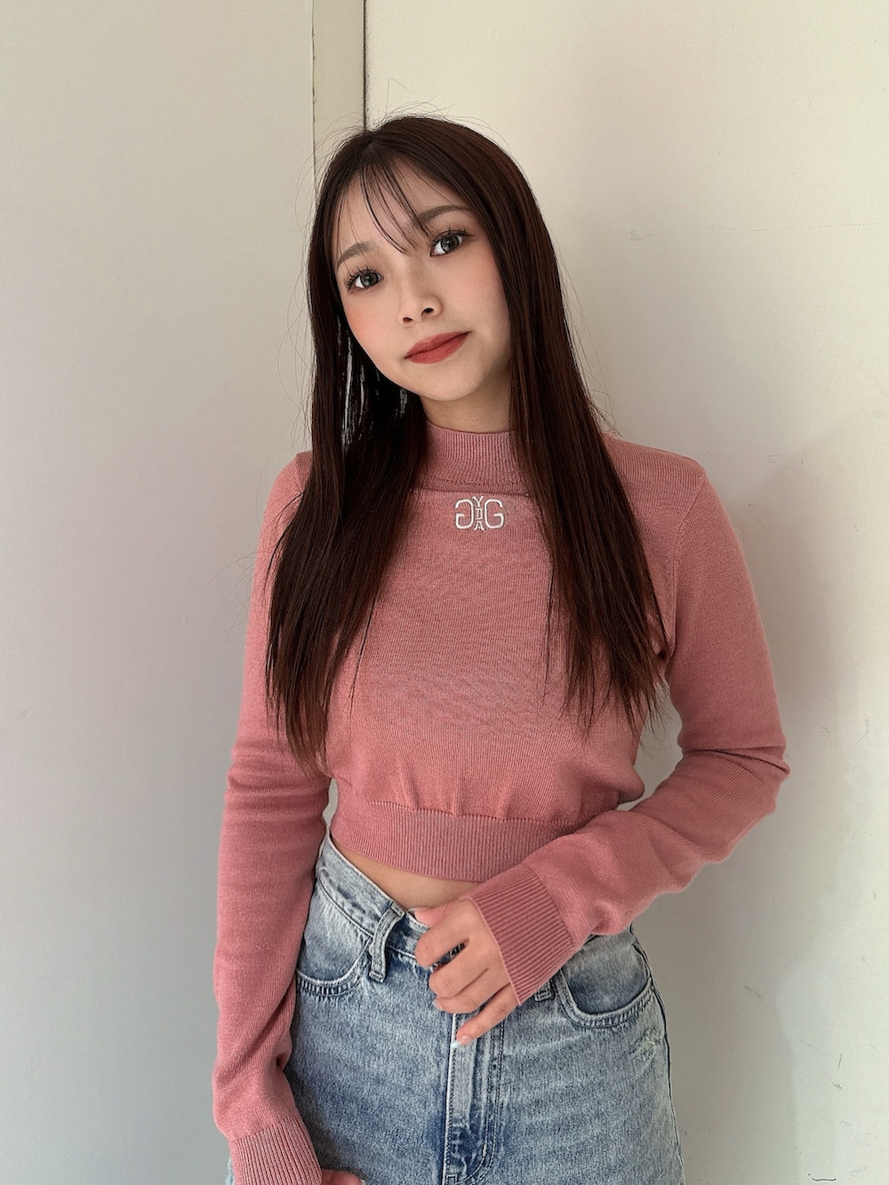 ブルー系のデニムパンツ、ピンク系のニット/セーター、ブラック系のブーツを着用したレディースの冬コーディネートの4枚目の写真