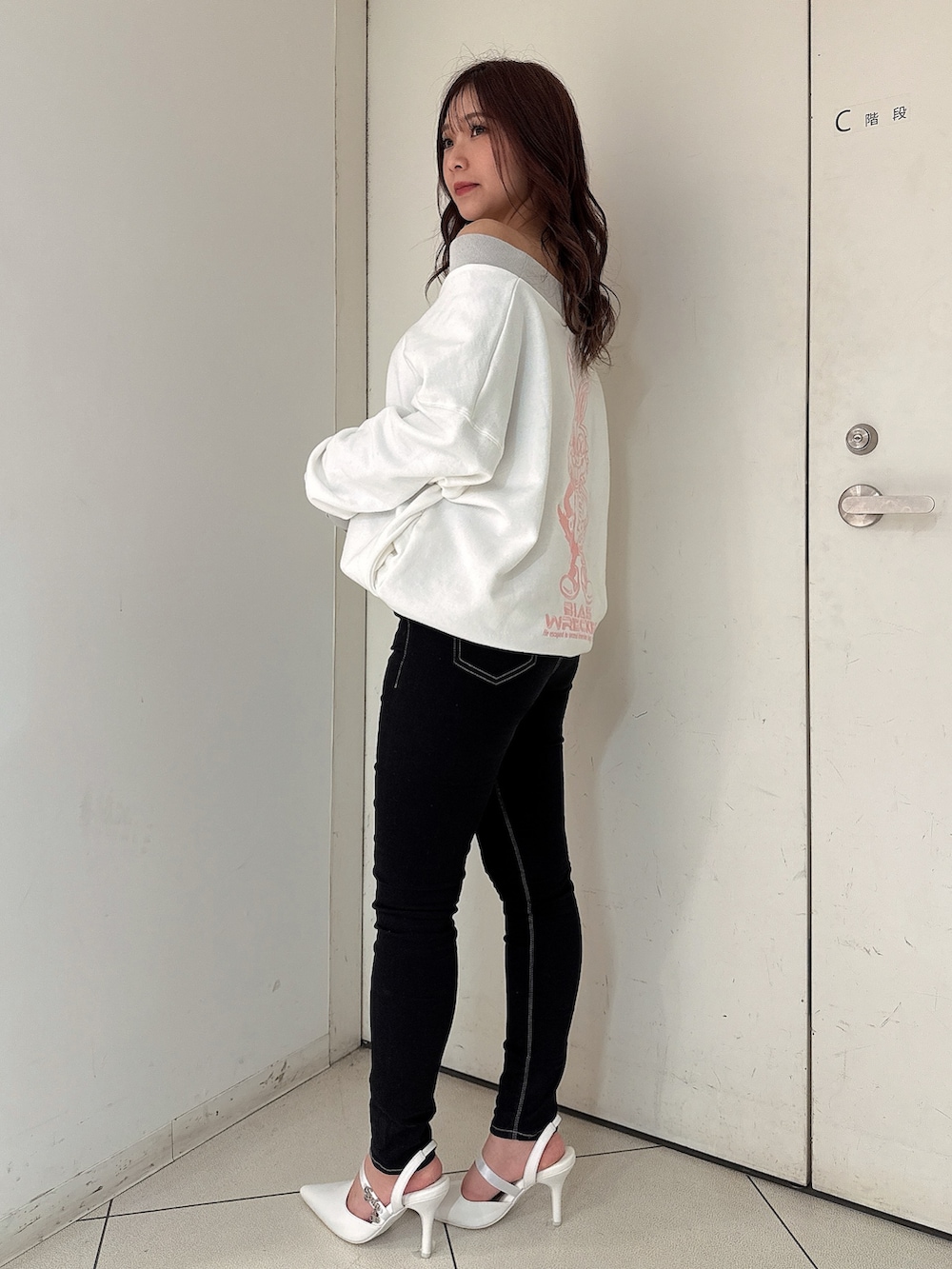 ブラック系のデニムパンツ、ホワイト系のスウェット、ホワイト系のパンプスを着用したレディースの冬コーディネートの2枚目の写真