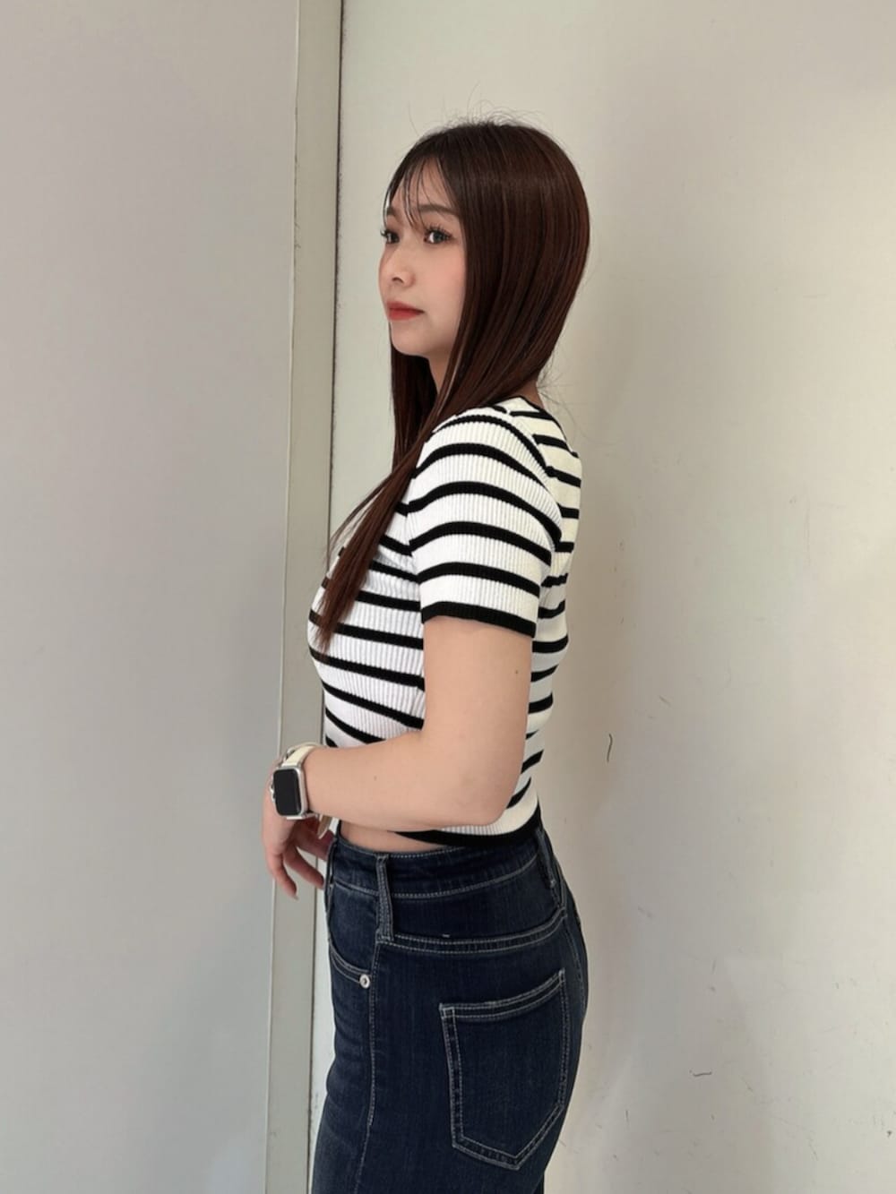 ブルー系のデニムパンツ、ブラック系のサンダル、その他のニット/セーターを着用したレディースの春コーディネートの5枚目の写真