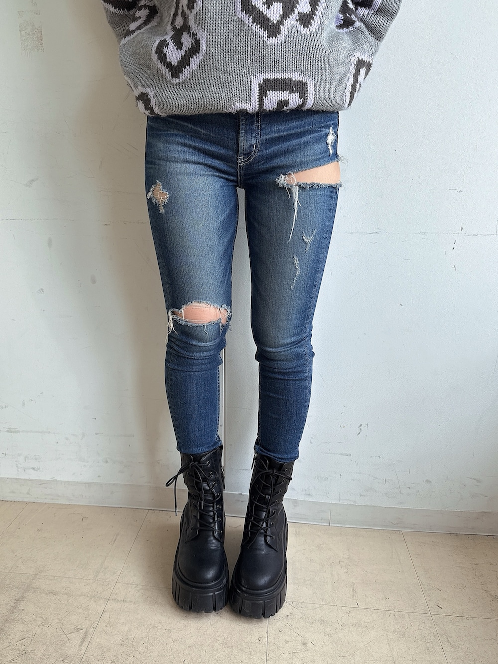 グレー系のニット/セーター、ブルー系のデニムパンツ、ブラック系のブーツを着用したレディースの秋コーディネートの8枚目の写真