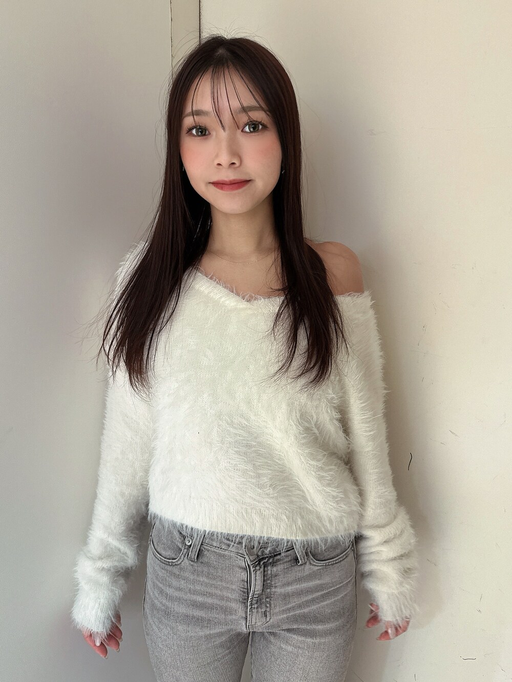 ホワイト系のニット/セーター、グレー系のデニムパンツ、ブラック系のブーツを着用したレディースの冬コーディネートの4枚目の写真
