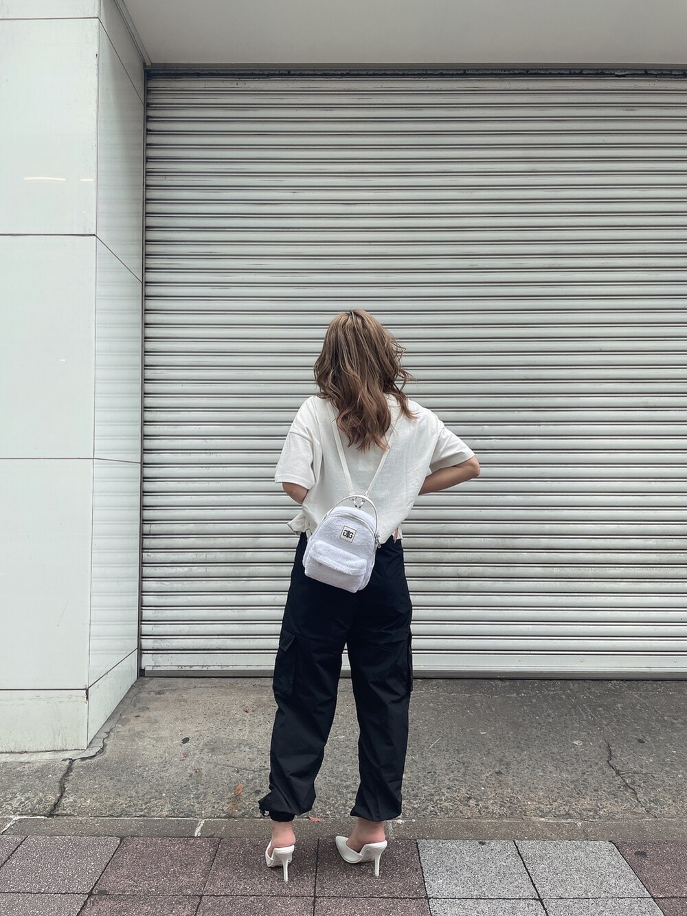 ホワイト系のバックパック/リュック、ホワイト系のTシャツ/カットソー、ブラック系のカーゴパンツを着用したレディースの夏コーディネートの3枚目の写真
