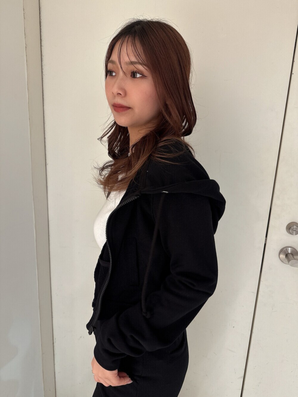 ホワイト系のパンプス、ブラック系のパーカー、ホワイト系のTシャツ/カットソーを着用したレディースの春コーディネートの5枚目の写真