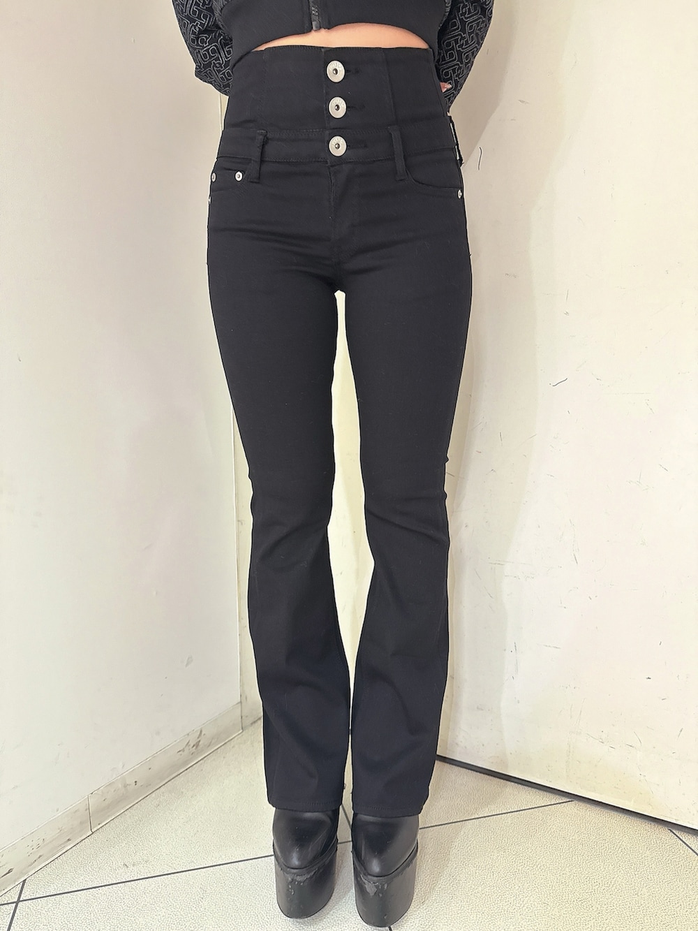 ブラック系のデニムパンツ、ブラック系のパーカー、ブラック系のブーツを着用したレディースの冬コーディネートの8枚目の写真