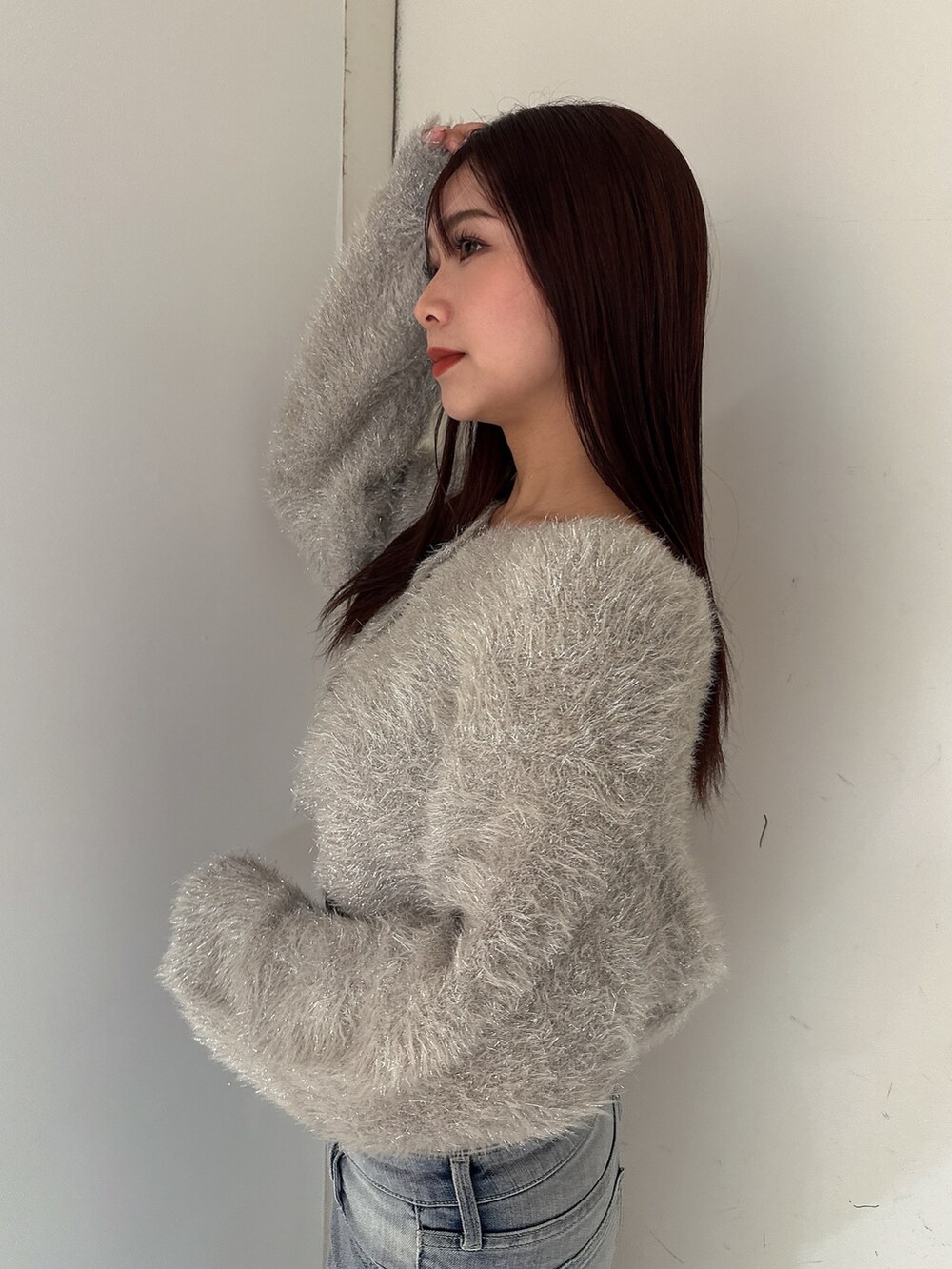 ブルー系のデニムパンツ、ホワイト系のパンプス、ベージュ系のカーディガン/ボレロを着用したレディースの秋コーディネートの5枚目の写真