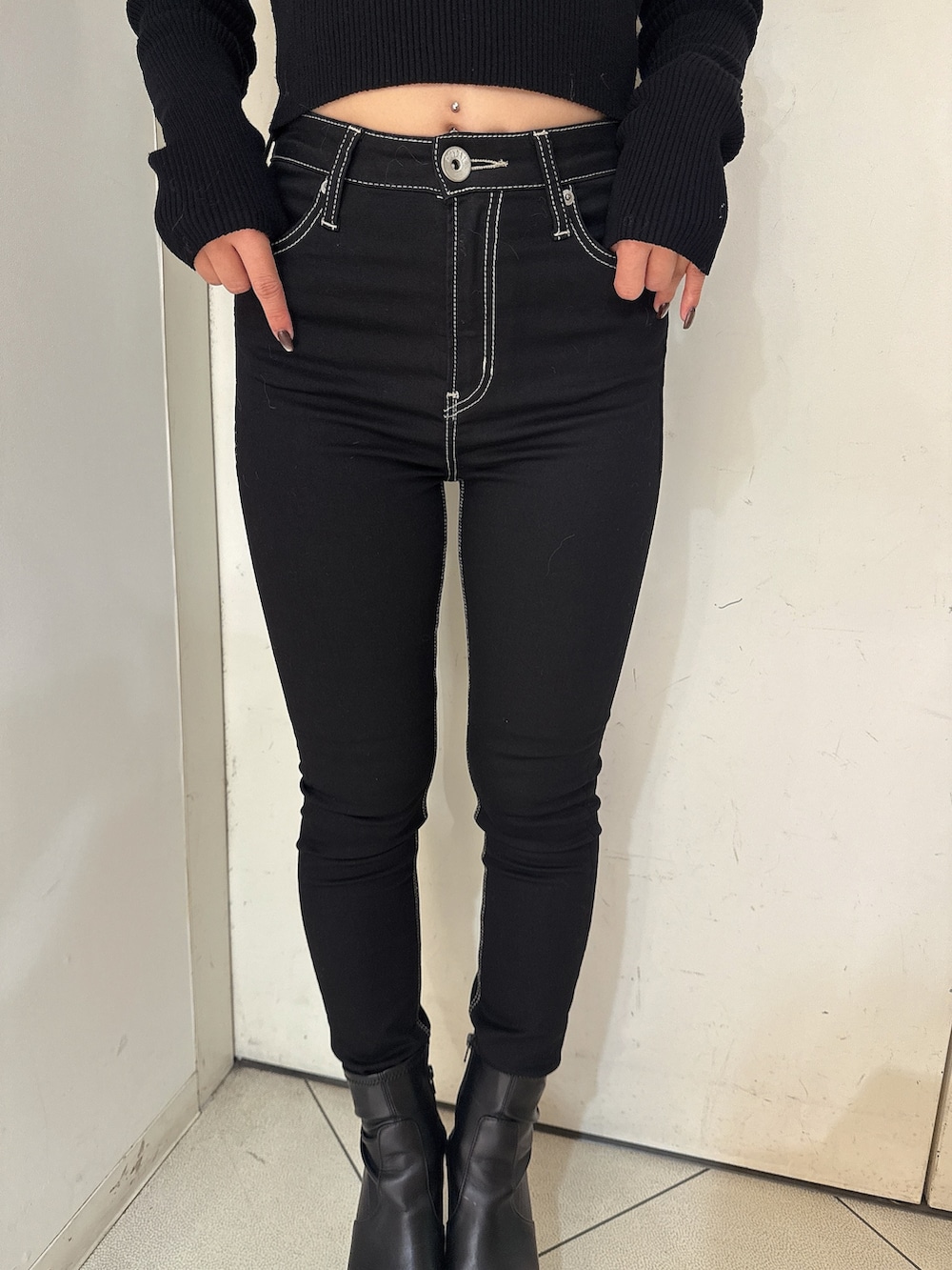 ブラック系のデニムパンツ、ブラック系のブーツ、ブラック系のニット/セーターを着用したレディースの秋コーディネートの9枚目の写真