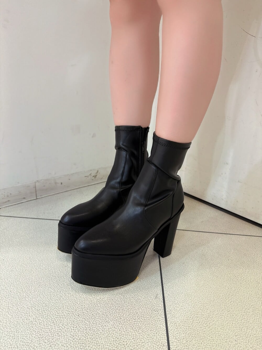 ブラック系のデニムパンツ、ブラック系のブーツ、ブラック系のニット/セーターを着用したレディースの夏コーディネートの9枚目の写真