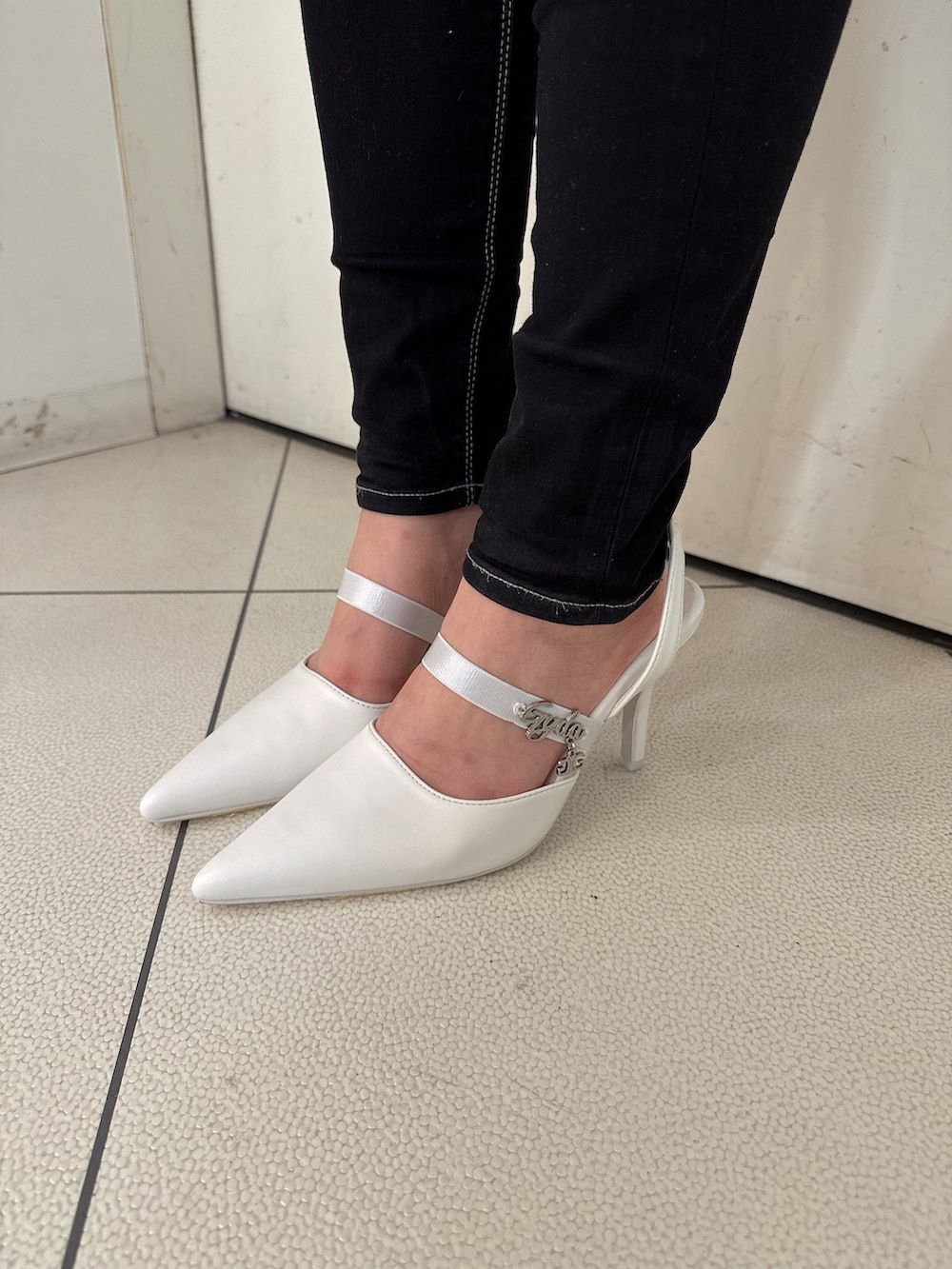 ブラック系のデニムパンツ、ホワイト系のスウェット、ホワイト系のパンプスを着用したレディースの冬コーディネートの10枚目の写真