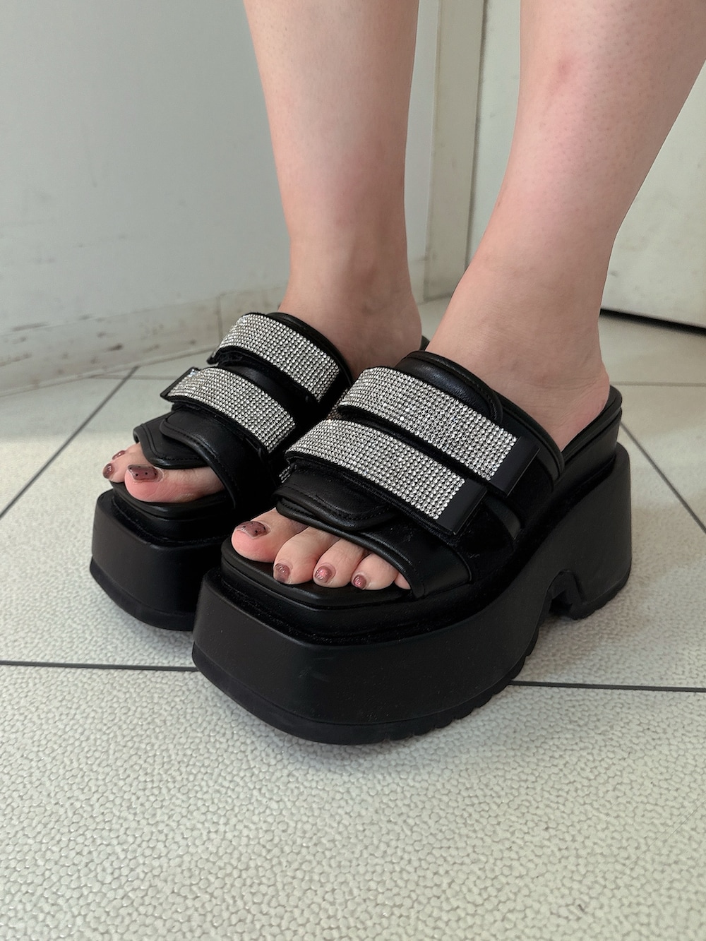 ブルー系のデニムパンツ、ブラック系のサンダル、ホワイト系のカーディガン/ボレロを着用したレディースの春コーディネートの9枚目の写真