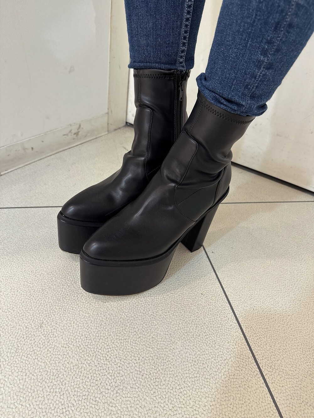 ブルー系のデニムパンツ、ブラック系のブーツ、ブラウン系のブルゾンを着用したレディースの秋コーディネートの9枚目の写真