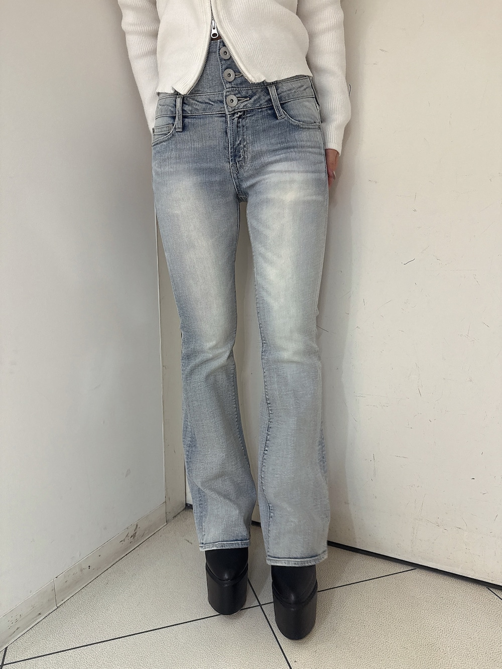 ホワイト系のニット/セーター、ブルー系のデニムパンツ、ブラック系のブーツを着用したレディースの秋コーディネートの9枚目の写真