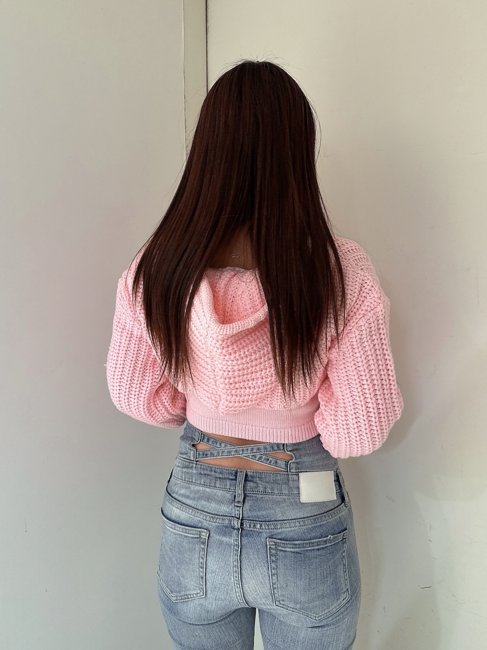 ブルー系のデニムパンツ、ピンク系のニット/セーター、ブラック系のブーツを着用したレディースの冬コーディネートの6枚目の写真