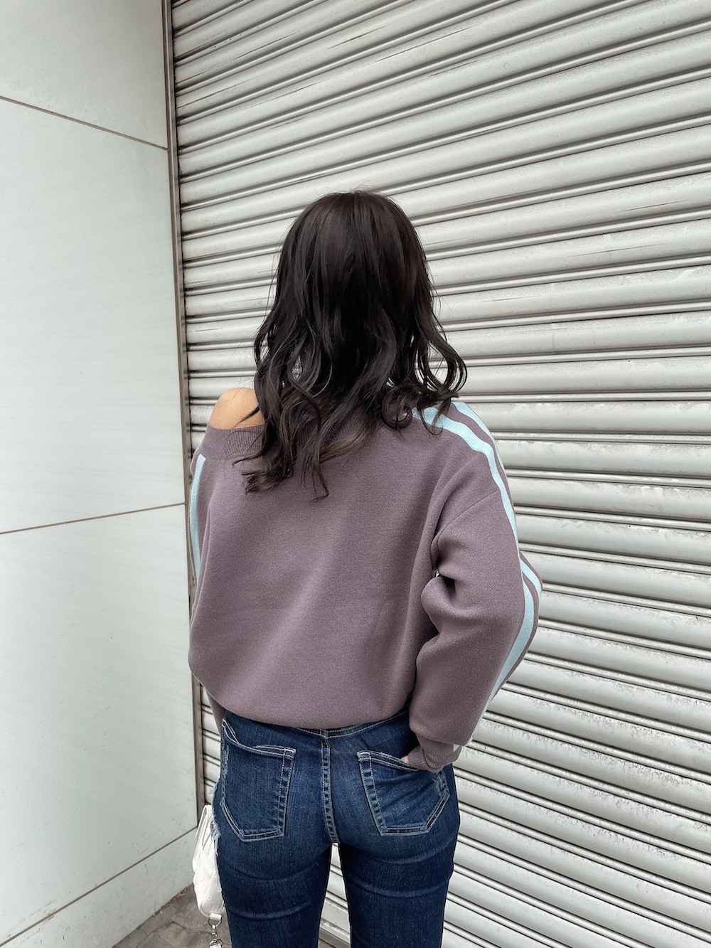 グレー系のニット/セーター、ブルー系のデニムパンツ、ブラック系のブーツを着用したレディースの冬コーディネートの5枚目の写真