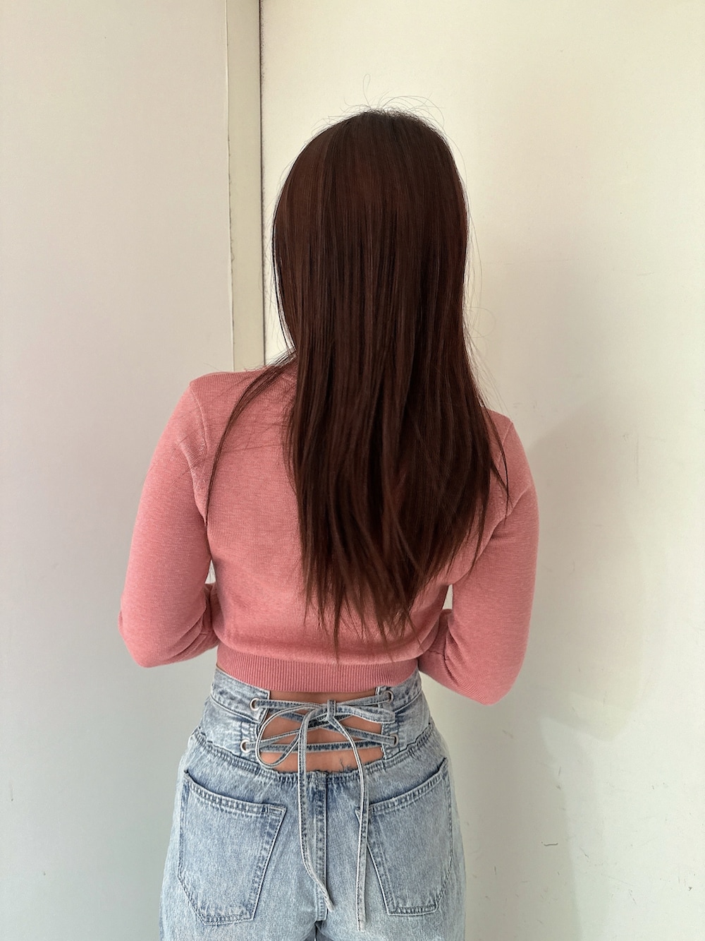 ブルー系のデニムパンツ、ピンク系のニット/セーター、ブラック系のブーツを着用したレディースの冬コーディネートの6枚目の写真