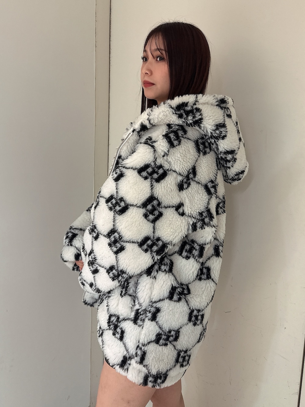 ホワイト系のブルゾン、ブラック系のスカート、ブラック系のブーツを着用したレディースの秋コーディネートの5枚目の写真