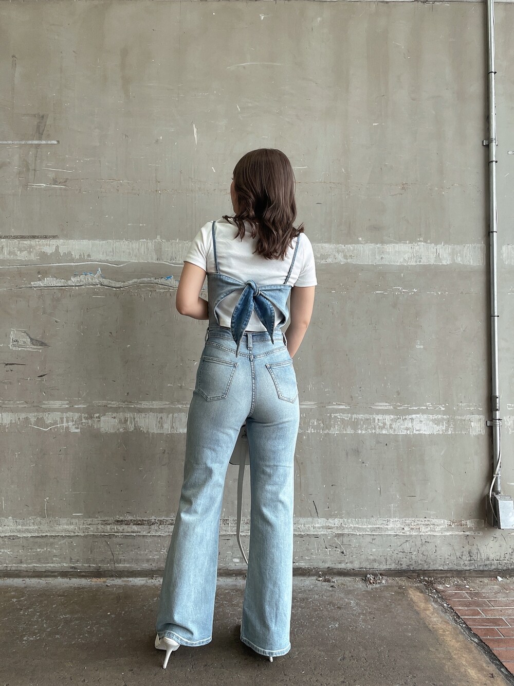 ホワイト系のTシャツ/カットソー、ホワイト系のハンドバッグ、ホワイト系のパンプスを着用したレディースの春コーディネートの2枚目の写真