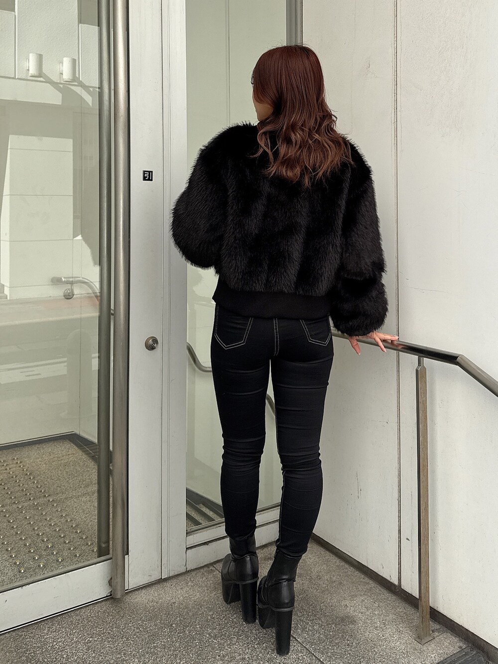 ブラック系のデニムパンツ、ブラック系のブーツ、ブラック系のその他アウターを着用したレディースの秋コーディネートの3枚目の写真