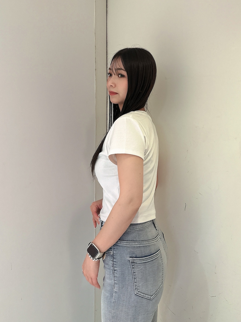 ブルー系のデニムパンツ、ホワイト系のTシャツ/カットソー、ホワイト系のサンダルを着用したレディースの春コーディネートの5枚目の写真