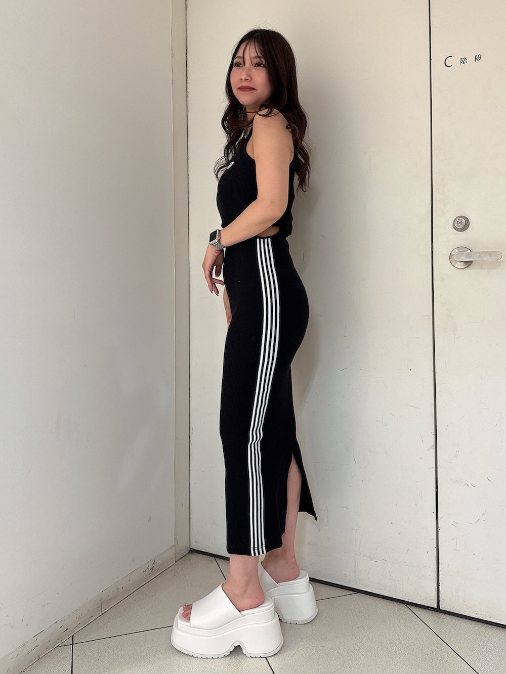 ブラック系のワンピース、ホワイト系のサンダルを着用したレディースの夏コーディネートの2枚目の写真