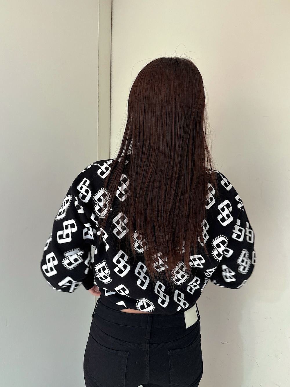 ブラック系のデニムパンツ、ブラック系のブーツ、ブラック系のスウェットを着用したレディースの冬コーディネートの6枚目の写真