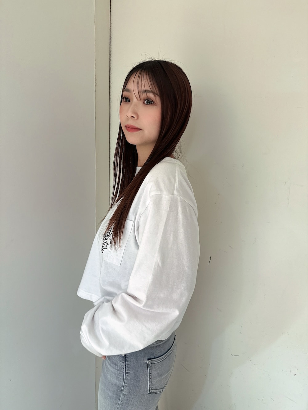 ブルー系のデニムパンツ、ホワイト系のTシャツ/カットソー、ブラック系のサンダルを着用したレディースの春コーディネートの5枚目の写真