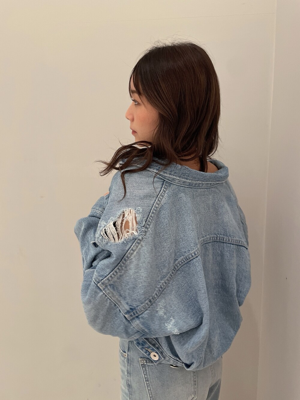 ホワイト系のサンダル、ブルー系のチューブトップ、ブルー系のデニムジャケットを着用したレディースの春コーディネートの5枚目の写真