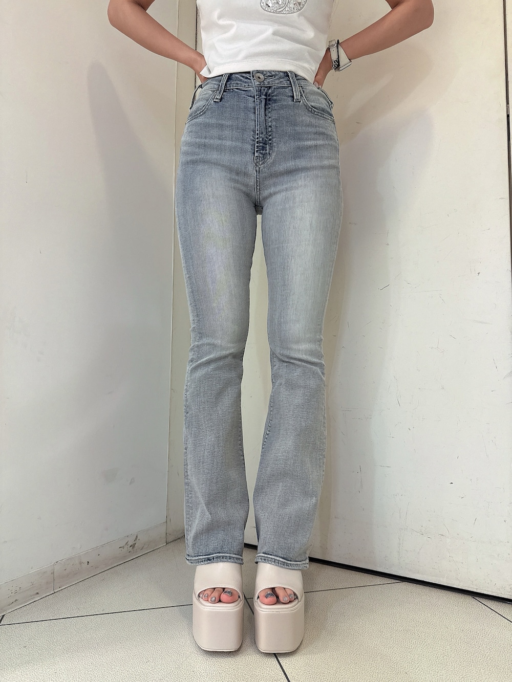 ブルー系のデニムパンツ、ホワイト系のTシャツ/カットソー、ホワイト系のサンダルを着用したレディースの春コーディネートの8枚目の写真