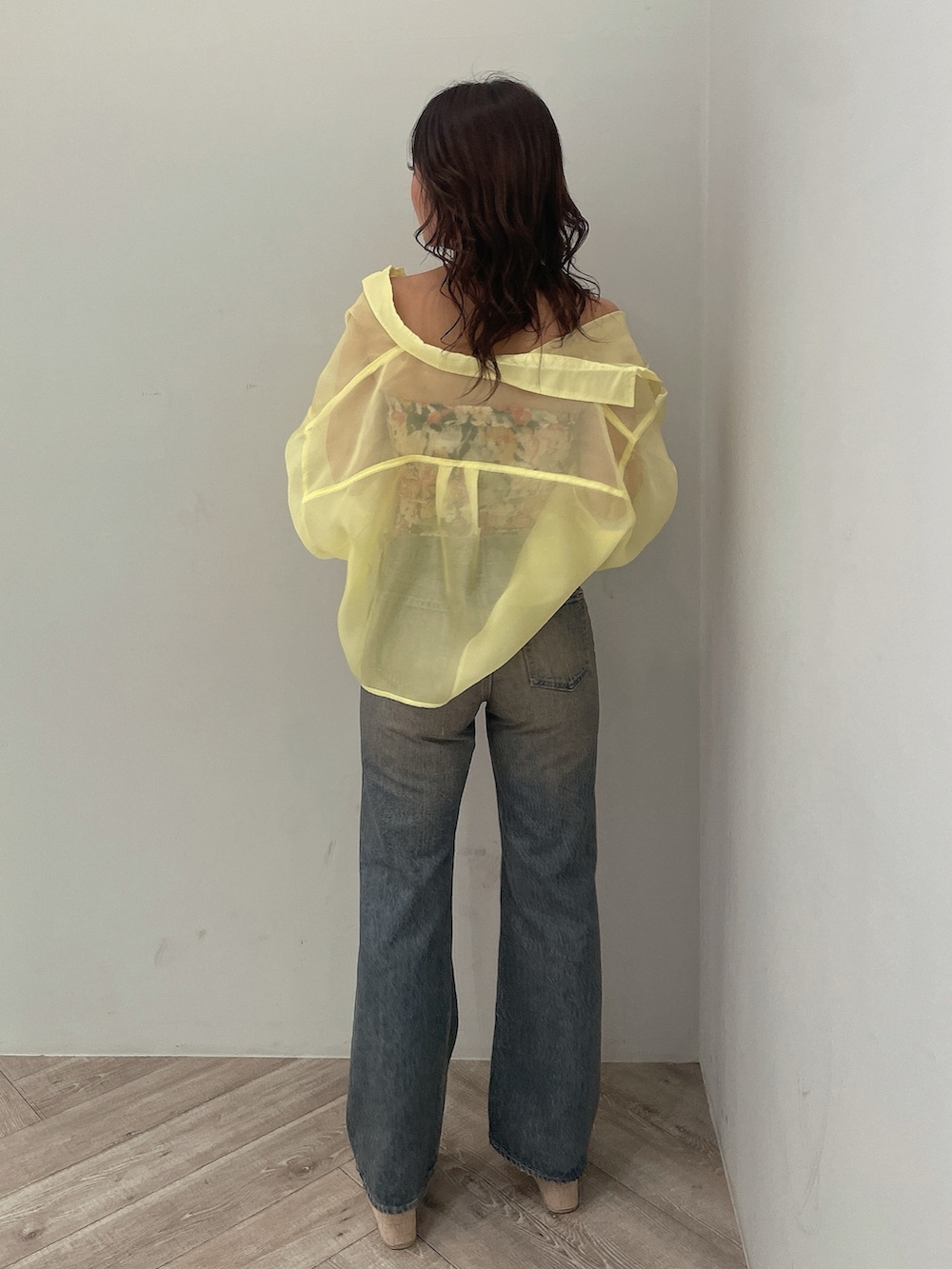 イエロー系のシャツ/ブラウス、ブラック系のチューブトップ、ブルー系のデニムパンツを着用したレディースの春コーディネートの4枚目の写真