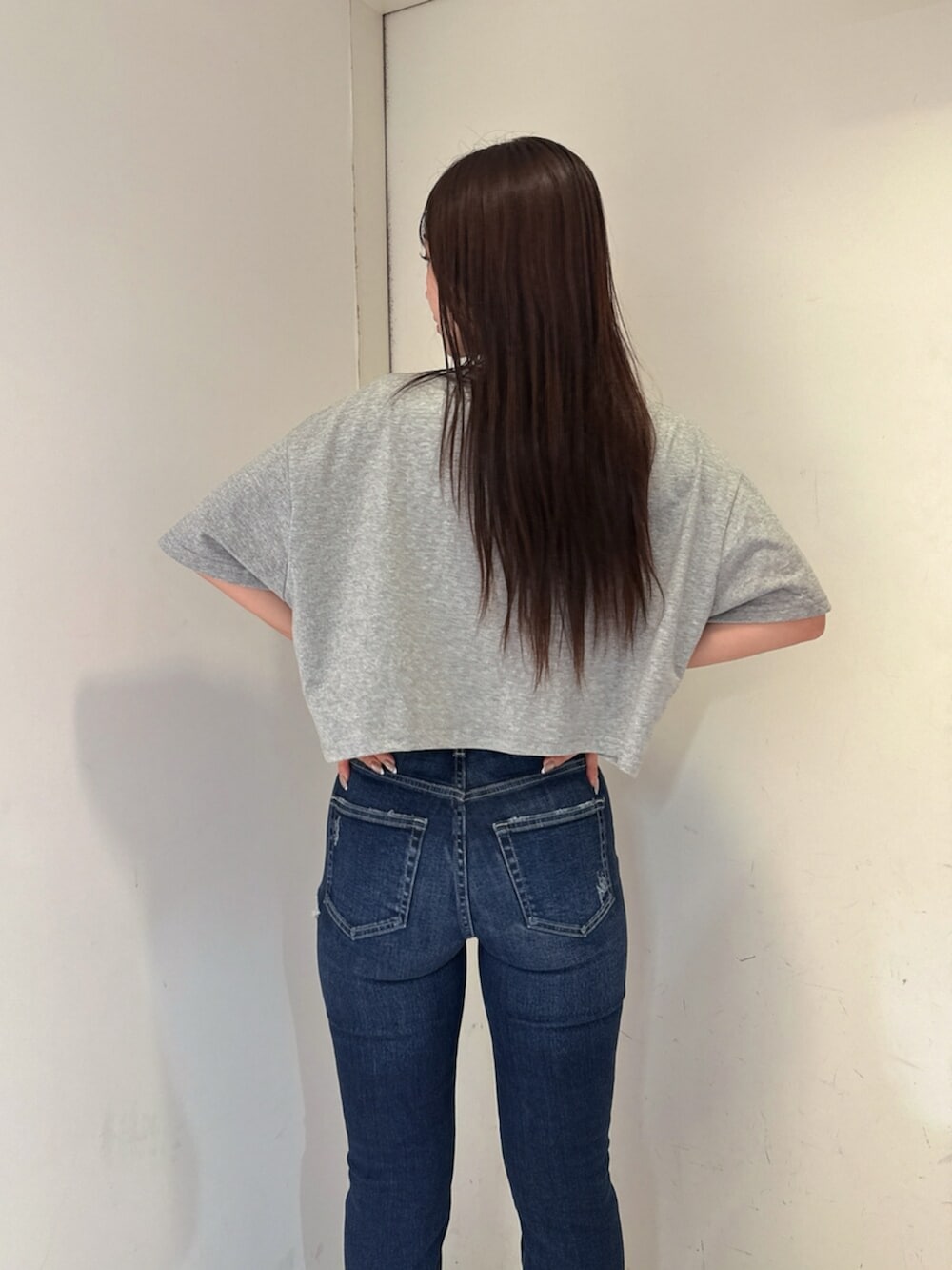 ブルー系のデニムパンツ、ブラック系のサンダル、グレー系のTシャツ/カットソーを着用したレディースの夏コーディネートの6枚目の写真