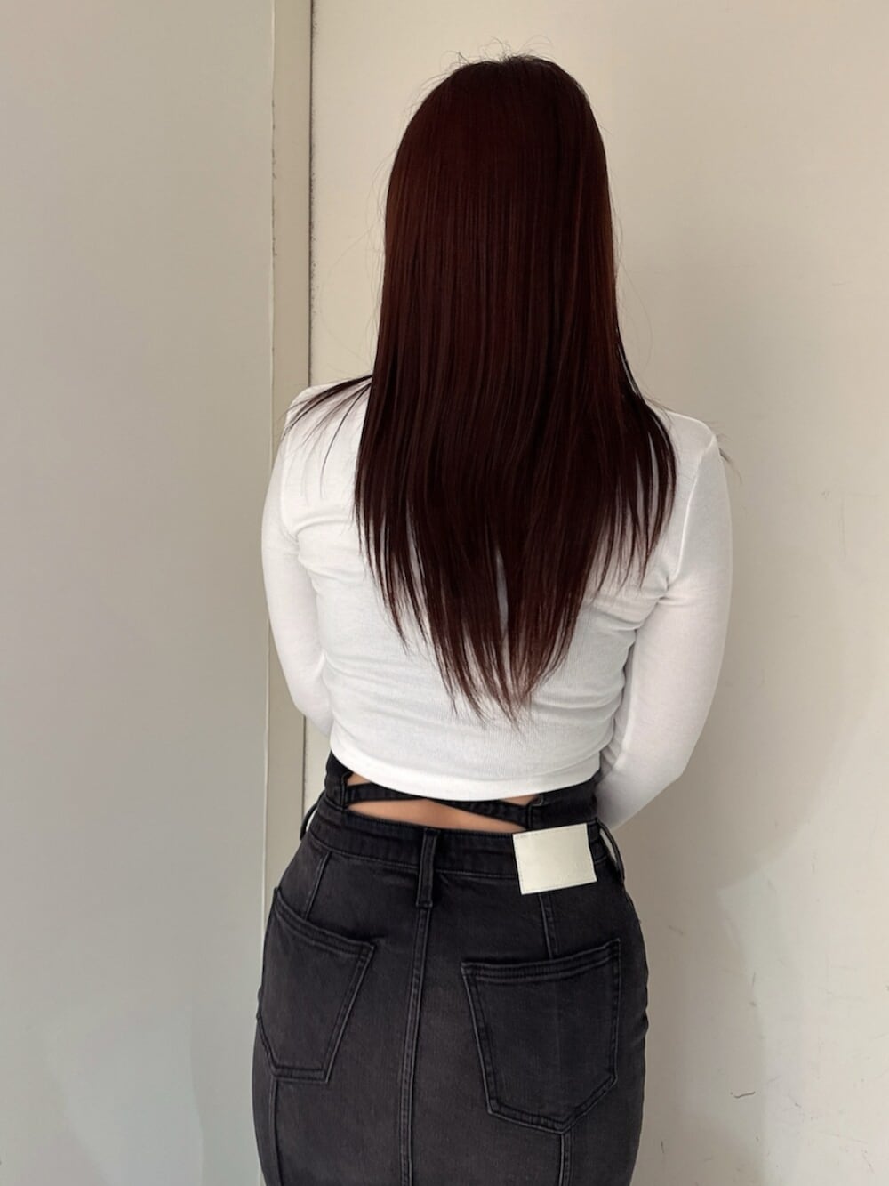 ブラック系のブーツ、ホワイト系のTシャツ/カットソー、ブラック系のデニムスカートを着用したレディースの秋コーディネートの6枚目の写真