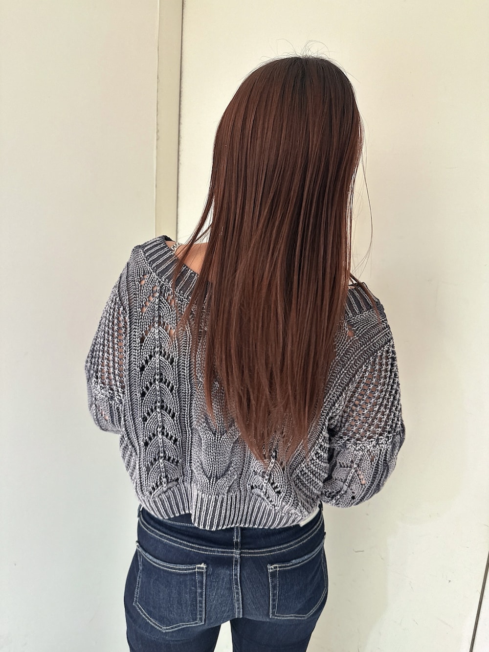 ブルー系のデニムパンツ、ブルー系のニット/セーター、ブラック系のサンダルを着用したレディースの春コーディネートの6枚目の写真