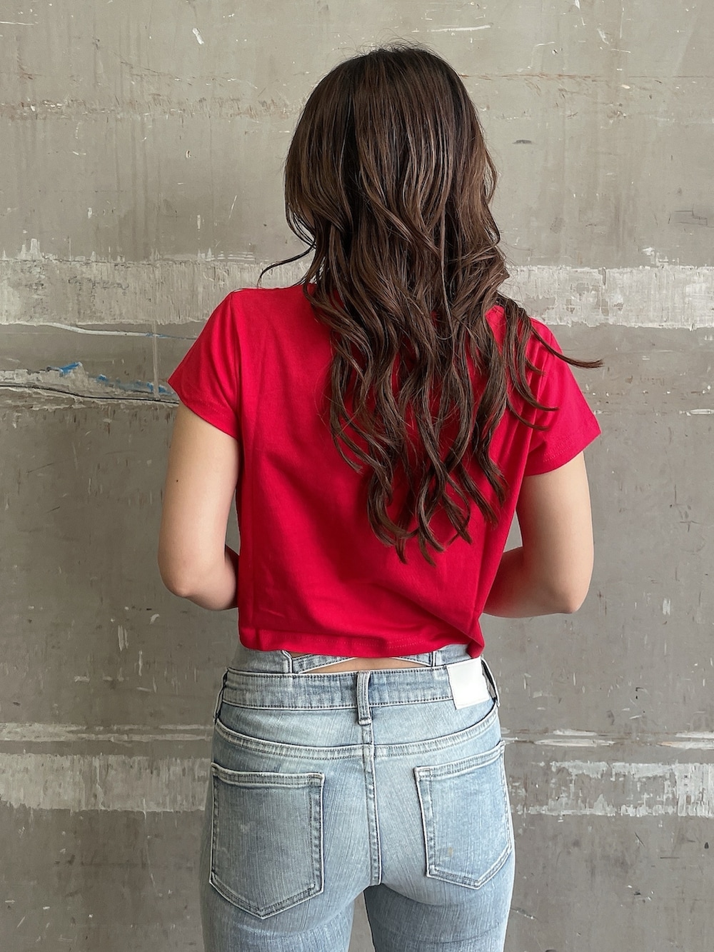 レッド系のTシャツ/カットソー、ブルー系のデニムパンツ、ホワイト系のサンダルを着用したレディースの夏コーディネートの5枚目の写真