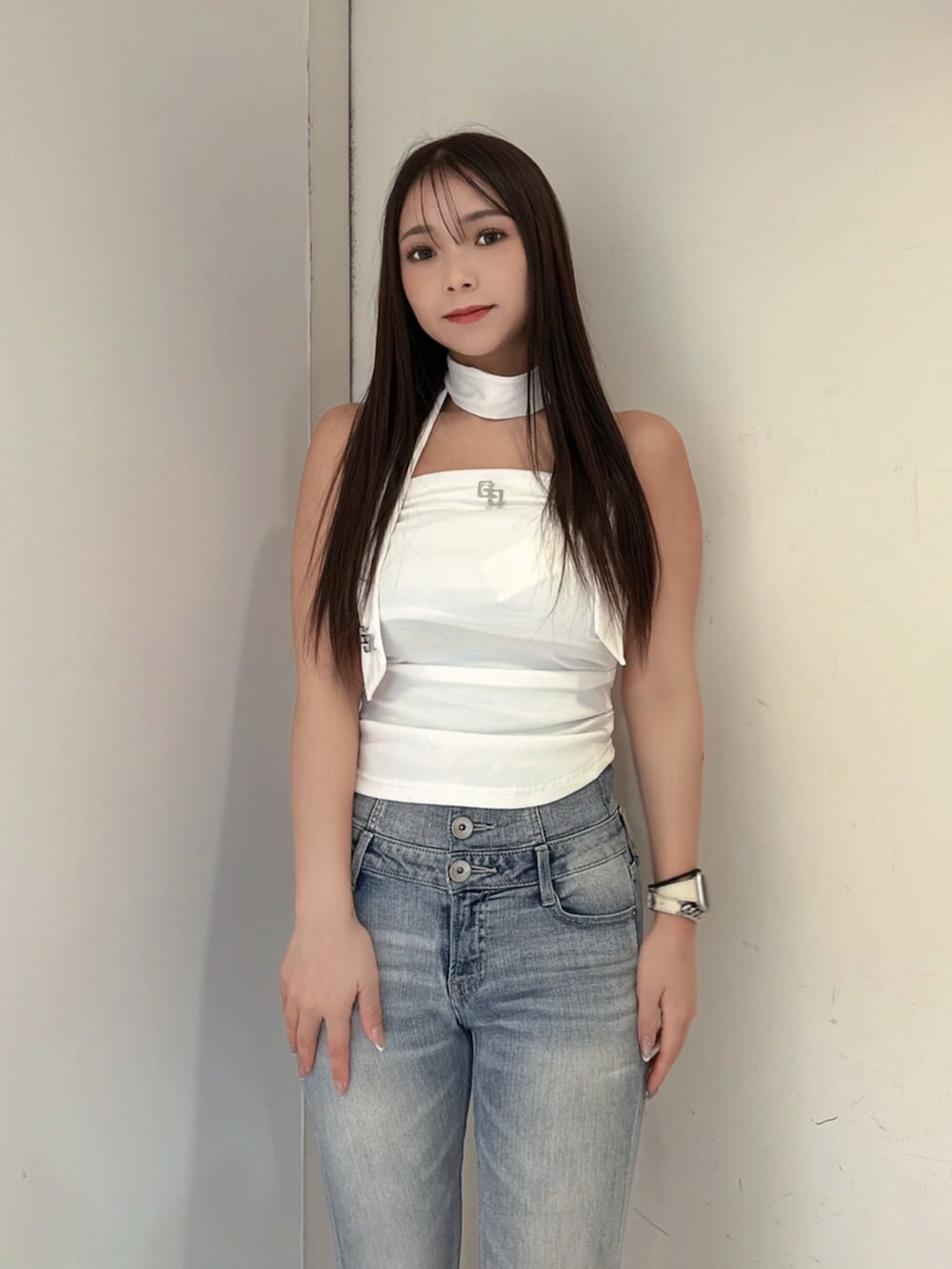 ブルー系のデニムパンツ、ホワイト系のサンダル、ホワイト系のチューブトップを着用したレディースの夏コーディネートの4枚目の写真