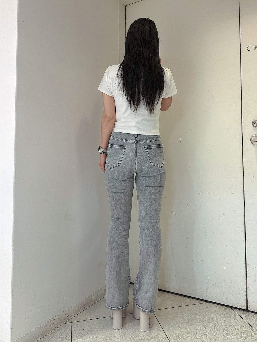ブルー系のデニムパンツ、ホワイト系のTシャツ/カットソー、ホワイト系のサンダルを着用したレディースの春コーディネートの3枚目の写真