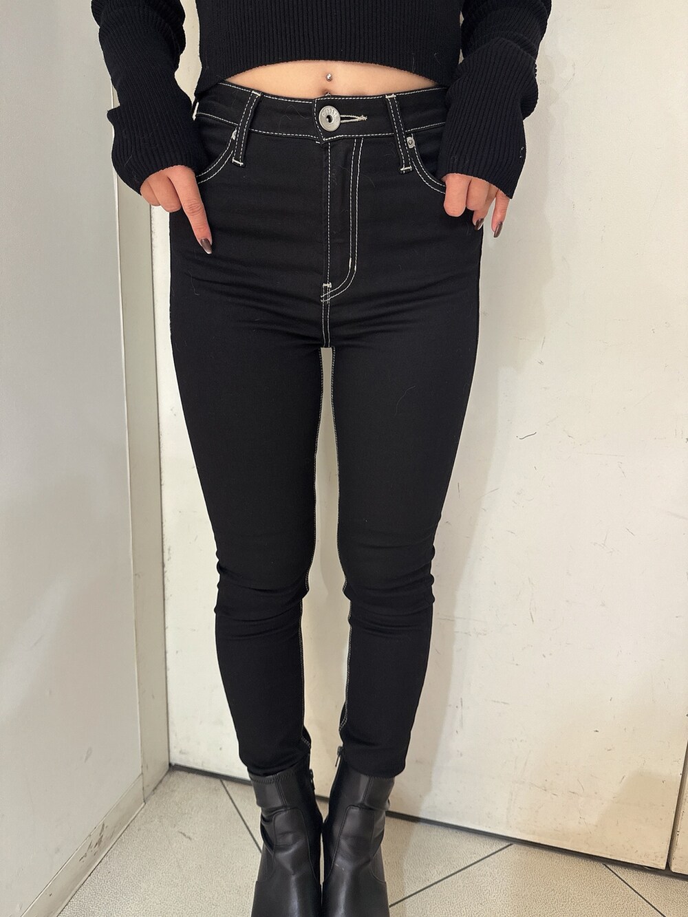 ホワイト系のニット/セーター、ブラック系のデニムパンツ、ブラック系のブーツを着用したレディースの秋コーディネートの8枚目の写真