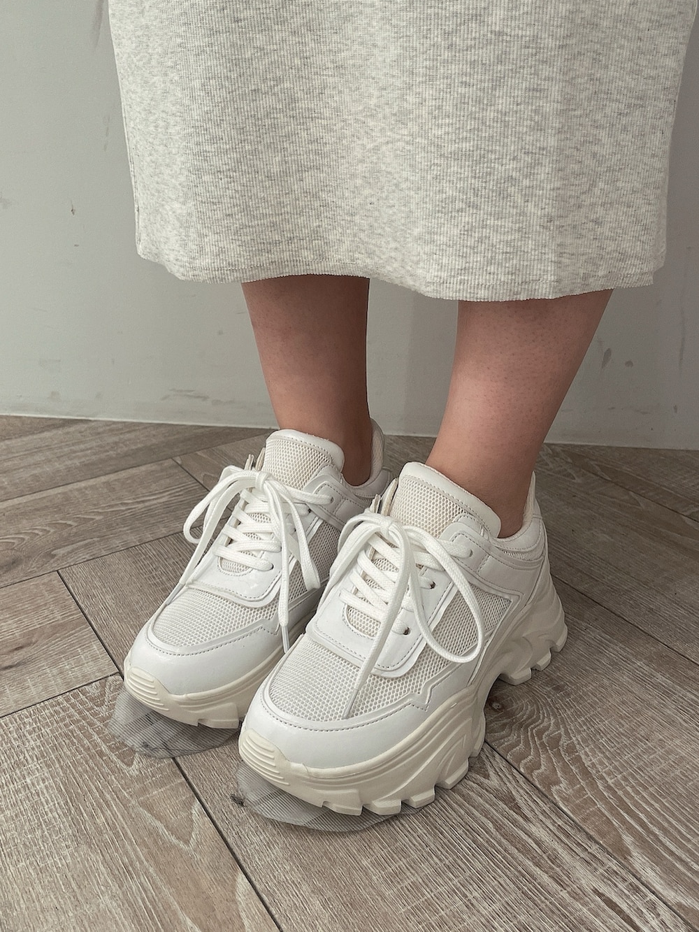 グレー系のワンピース、ブラック系のハンドバッグ、ホワイト系のスニーカーを着用したレディースの春コーディネートの8枚目の写真