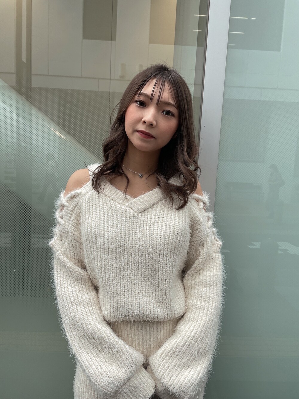 ブラック系のハンドバッグ、ブラック系のブーツ、ホワイト系のニット/セーターを着用したレディースの秋コーディネートの4枚目の写真