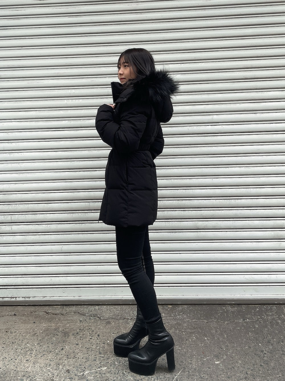 ブラック系のダウンジャケット/コート、ホワイト系のニット/セーター、ブラック系のデニムパンツを着用したレディースの冬コーディネートの2枚目の写真