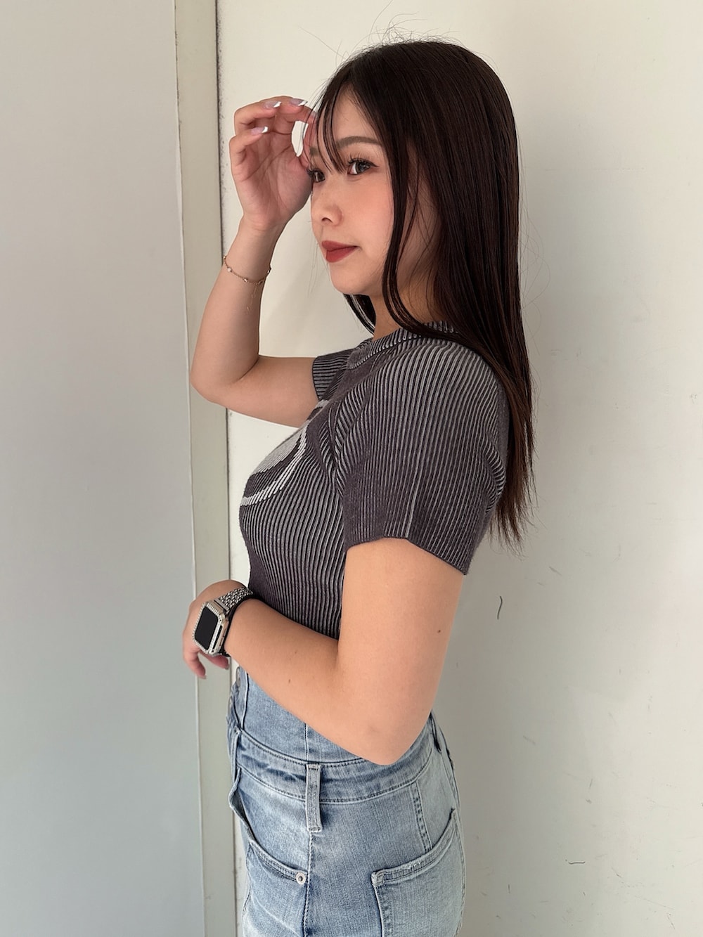 ホワイト系のニット/セーター、ブルー系のデニムスカート、ホワイト系のサンダルを着用したレディースの夏コーディネートの5枚目の写真